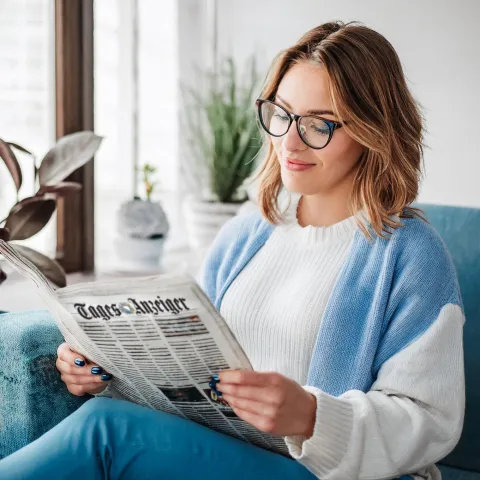 Junge Frau liest Zeitung Tages-Anzeiger