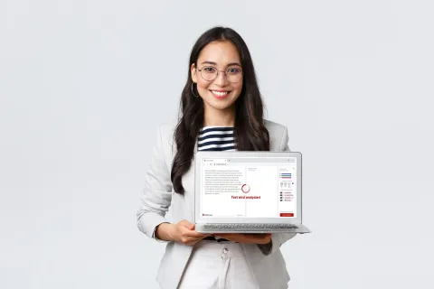 Person hält Laptop in der Hand, auf der das KI-Vereinfachungstool capito einen Text automatisiert übersetzt.